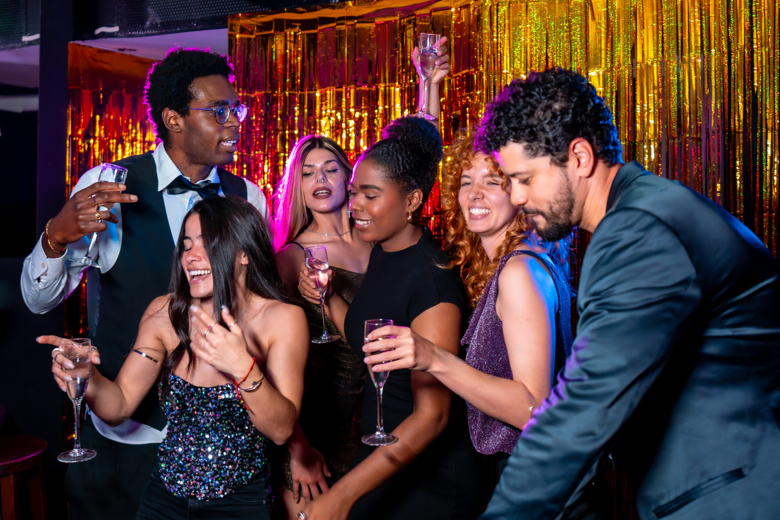 Friends celebrating in a vibrant nightclub, enjoying drinks and dancing, reflecting a lively atmosphere suitable for events like prom or anniversaries.