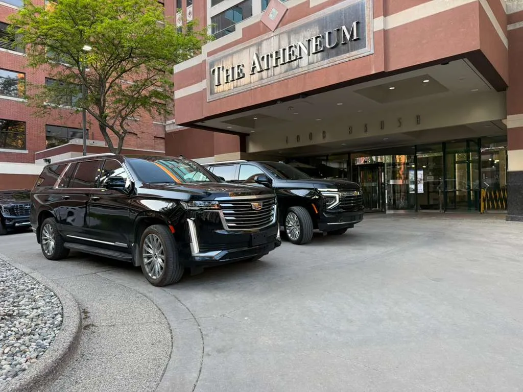 Business traveler engaging with chauffeur in luxury black car, reflecting positive experiences with Detroit black car services